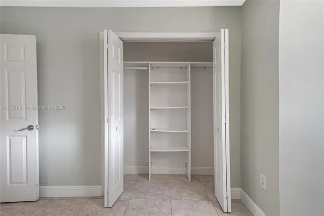 a view of walk in closet with empty racks