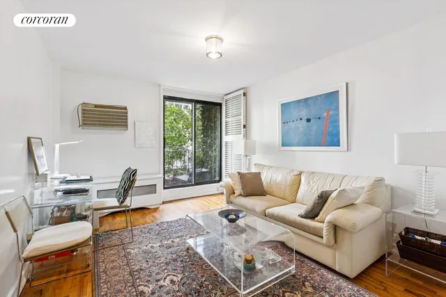 a living room with furniture wooden floor and a window