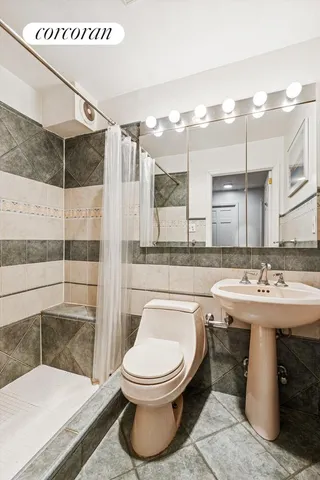 a bathroom with a sink a toilet and shower