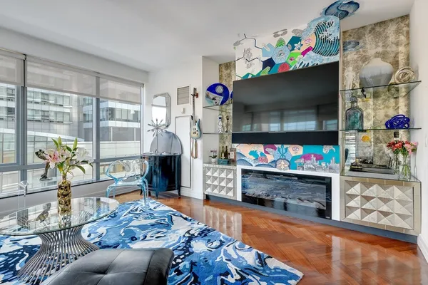a living room with furniture a flat screen tv and a fireplace