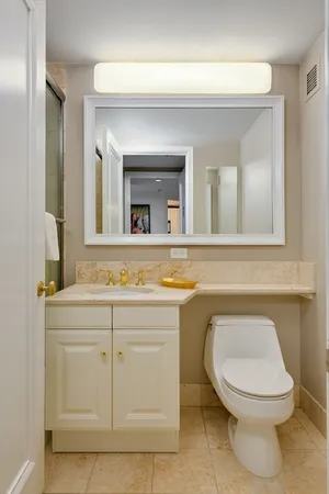 a bathroom with a toilet a sink and mirror