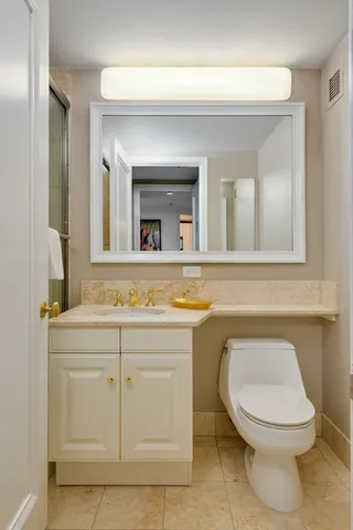 a bathroom with a toilet a sink and mirror