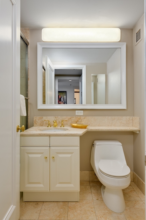 1 Avery Street, Unit 10D Boston, MA 02111 - Photo 13 of 21 a bathroom with a toilet a sink and mirror