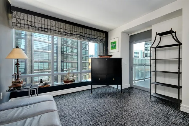 a living room with furniture a window and a flat screen tv