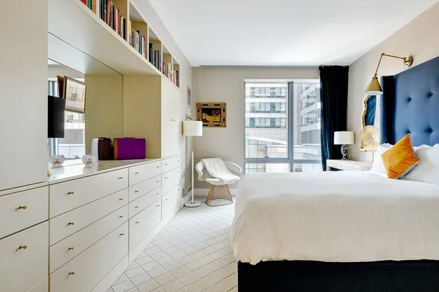 a bedroom with a bed and dresser with mirror