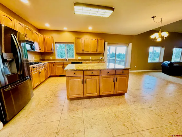 a kitchen with stainless steel appliances granite countertop a stove a sink and a refrigerator