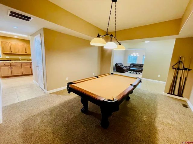 a room with pool table and windows