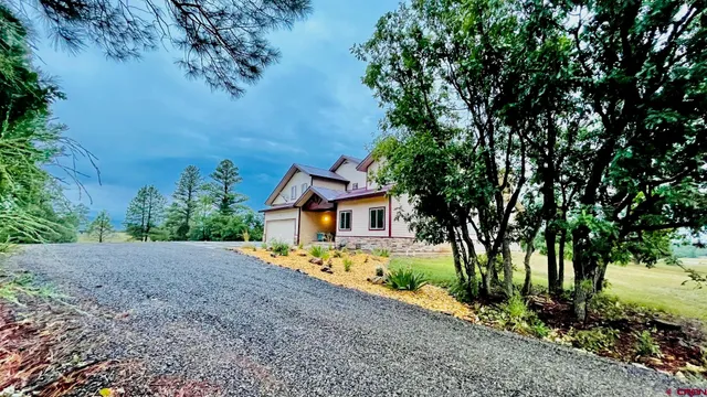 a view of a house with a tree in front of it