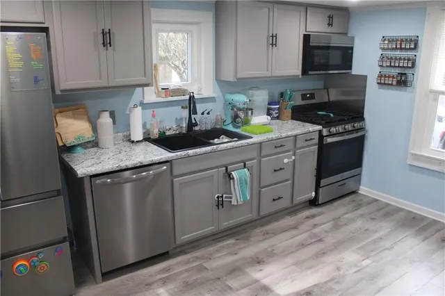 a kitchen with stainless steel appliances granite countertop a sink stove and cabinets