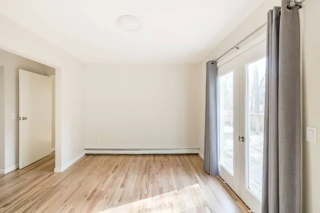 a view of a room with wooden floor and a window