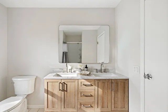 a bathroom with a granite countertop sink mirror and a toilet