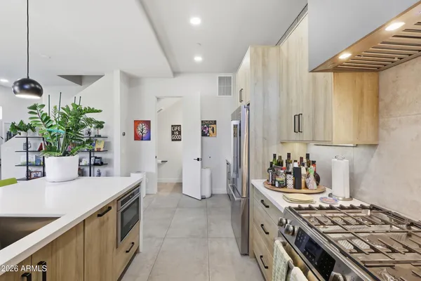 a kitchen with stainless steel appliances kitchen island a stove a refrigerator and a sink