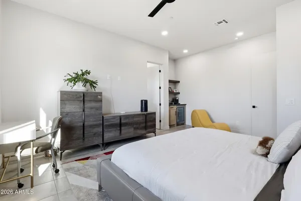a bedroom with a bed a chair and potted plant