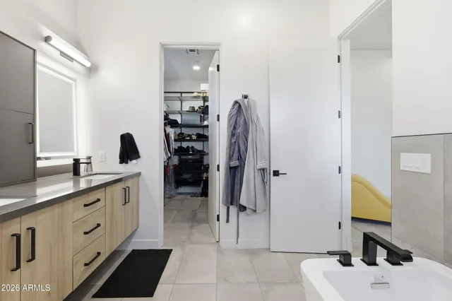 a spacious bathroom with a double vanity sink a mirror and shower