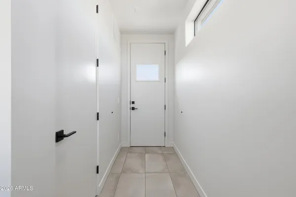 a view of a hallway with wooden floor and a bathroom
