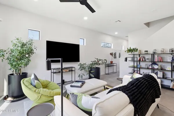 a living room with furniture a flat screen tv and a potted plant
