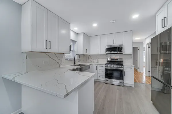 a kitchen with stainless steel appliances a stove a sink a microwave and cabinets
