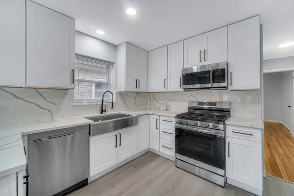 a kitchen with cabinets stainless steel appliances a sink and a counter space