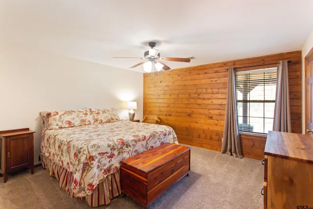 a bedroom with a bed and a dresser with rug