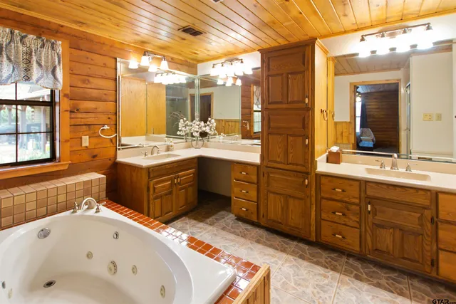 a bathroom with a tub sink and mirror