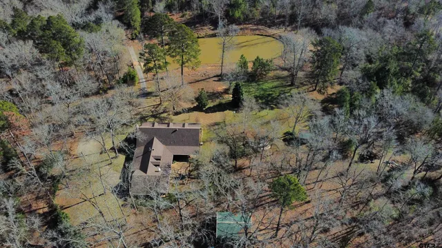 an aerial view of a house with a yard and large trees