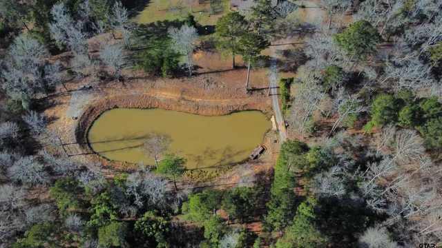 an aerial view of a house with a yard and trees