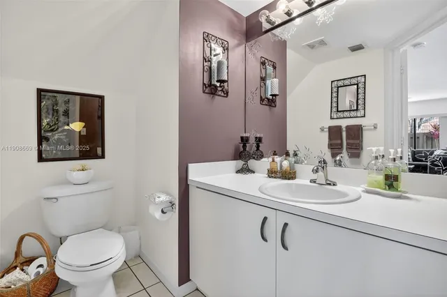 a bathroom with a toilet sink vanity shower and mirror