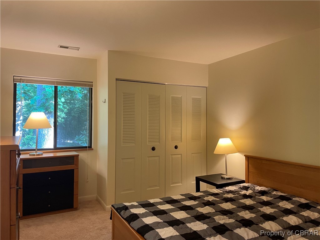 68 Villa Ridge Drive, Unit 4F Hartfield, VA 23071 - Photo 21 of 23 Bedroom with light colored carpet and a???????????????????????????????? closet