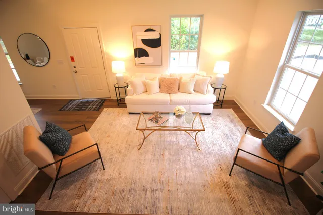 a living room with furniture wooden floor and a large window