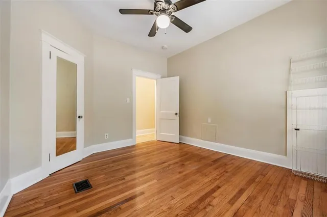 a view of an empty room with window and wooden floor