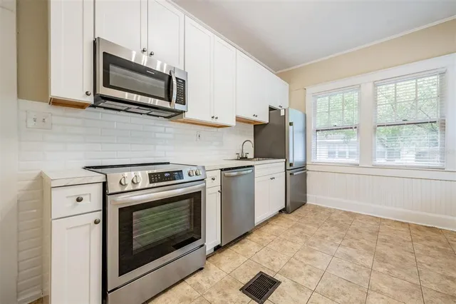 a kitchen with granite countertop a stove top oven microwave and cabinets
