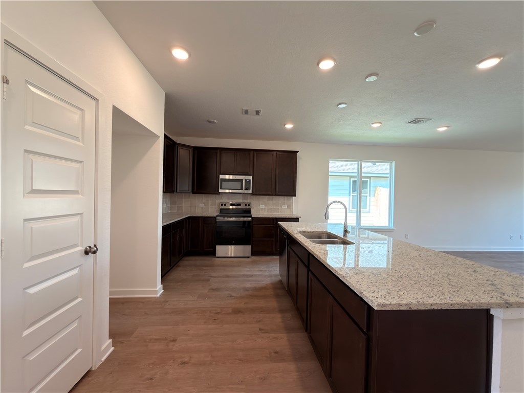 6053 Badger Street Bryan, TX 77807 - Photo 5 of 13 a large kitchen with a large counter top appliances and cabinets