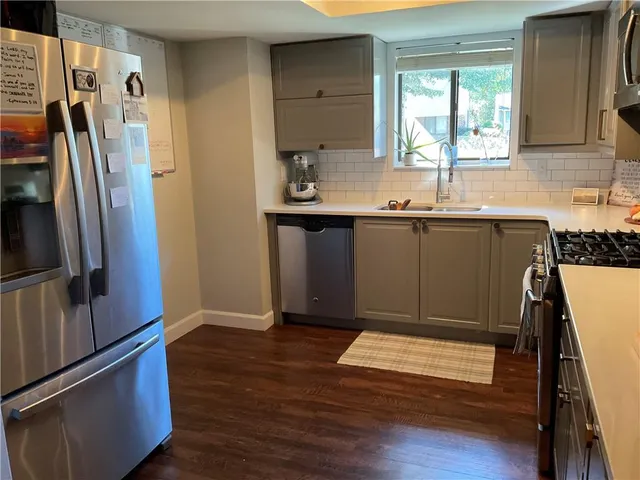 a kitchen with stainless steel appliances granite countertop a refrigerator and a sink