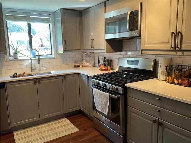 a kitchen with stainless steel appliances a stove a sink and a microwave