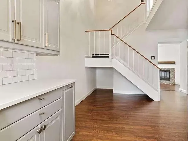 a hallway with wooden floor and staircase