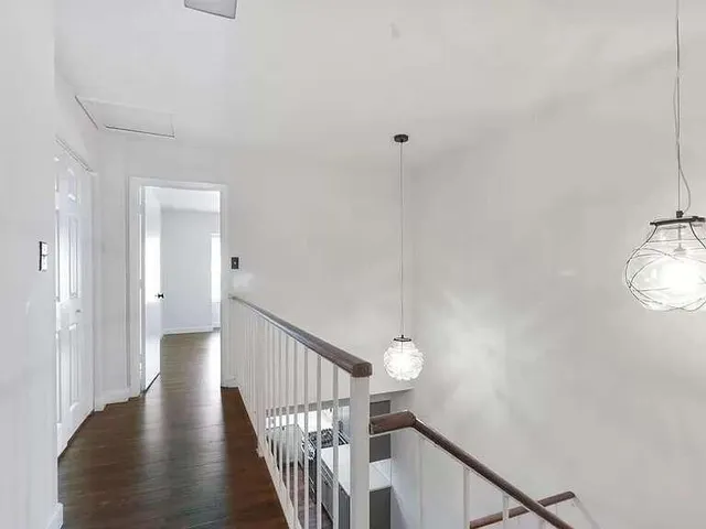 a view of a hallway with wooden floor and staircase