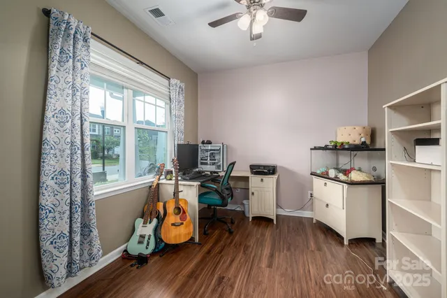 a kitchen with a stove a sink a kitchen island with chairs and wooden floor