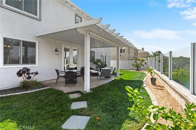 a view of a patio with couches chairs potted plants and a big yard