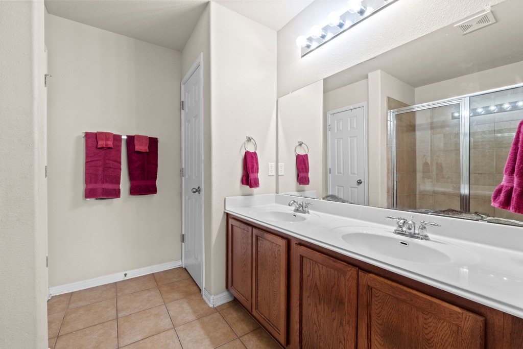 12008 Lansdowne Road Austin, TX 78754 - Photo 18 of 29 Double vanities and a spacious shower elevate this primary bathroom's function and style.