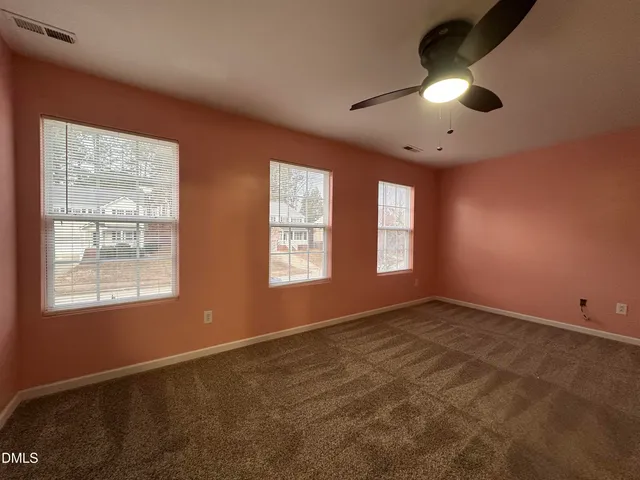 en empty room with windows and ceiling fan