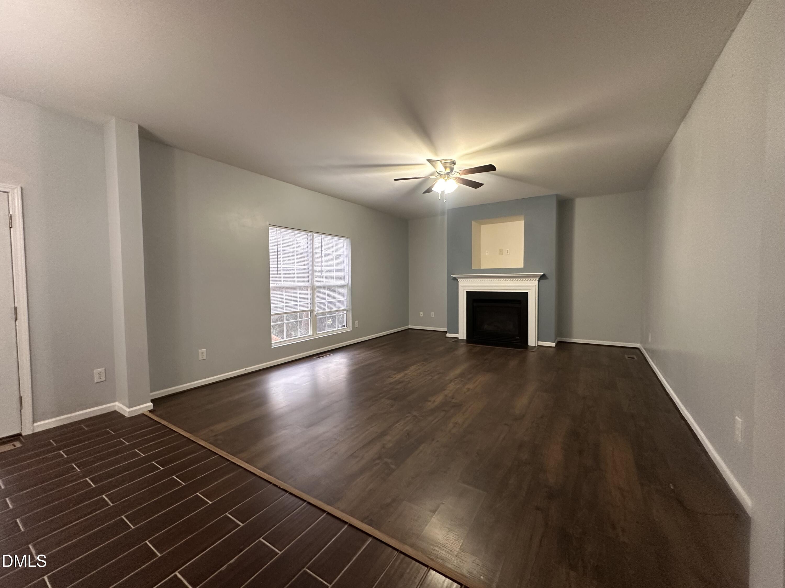 1220 Arbor Greene Drive Garner, NC 27529 - Photo 3 of 17 an empty room with wooden floor fireplace and windows