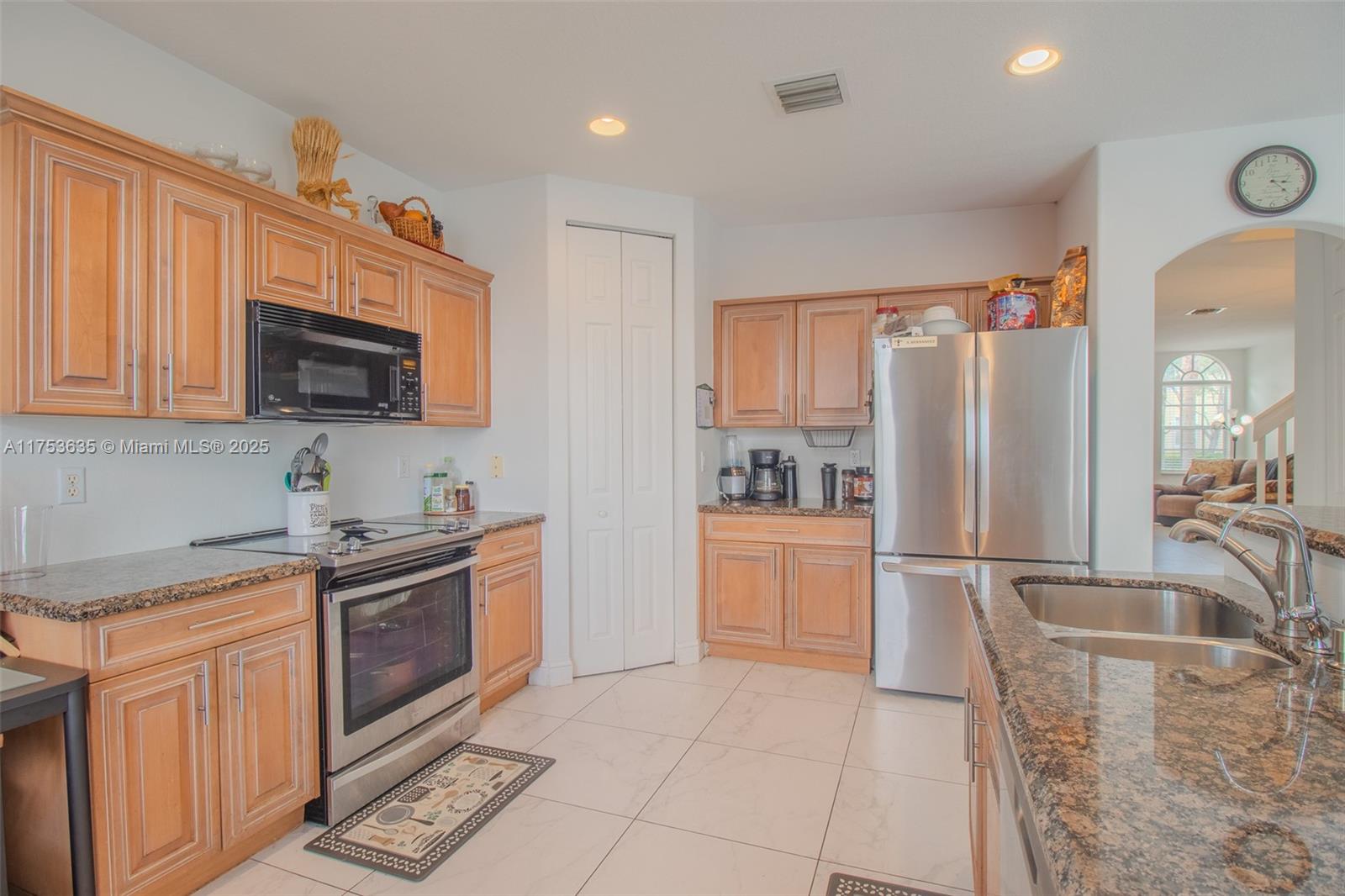 2695 Southwest 84th Terrace, Unit 104 Miramar, FL 33025 - Photo 15 of 36 a kitchen with stainless steel appliances granite countertop a refrigerator stove top oven and sink