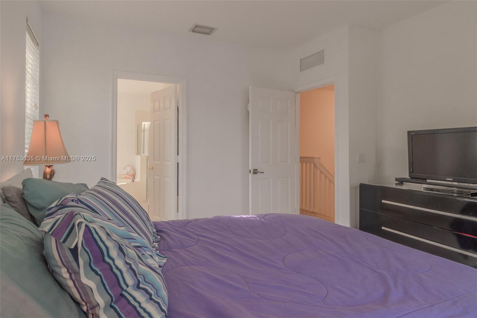 2695 Southwest 84th Terrace, Unit 104 Miramar, FL 33025 - Photo 32 of 36 a bedroom with a bed and a flat screen tv