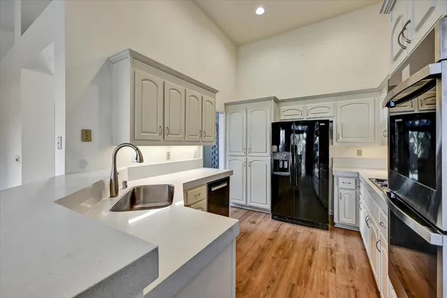 a kitchen with kitchen island a sink appliances and cabinets
