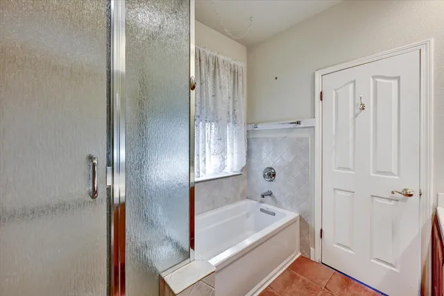 a bathroom with a tub shower and a sink