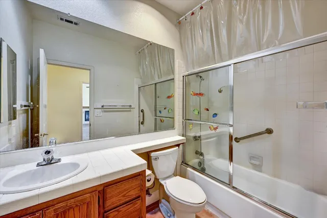 a bathroom with a granite countertop sink toilet and shower