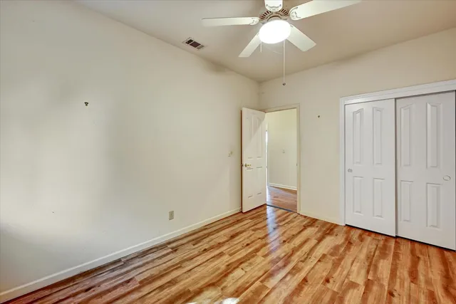 a view of a room with wooden floor and white walls