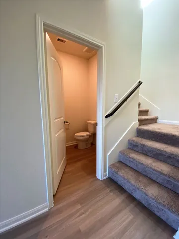 a view of a hallway with wooden floor and staircase