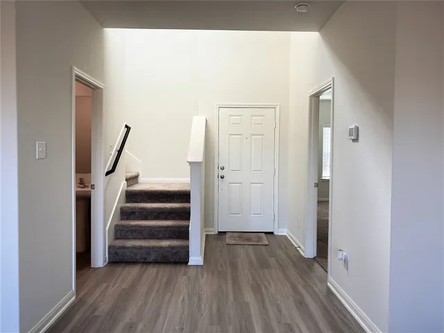 a view of a hallway with wooden floor and entryway