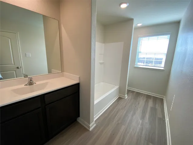 a bathroom with a sink a mirror and a bathtub